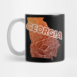 Colorful mandala art map of Georgia with text in brown and orange Mug